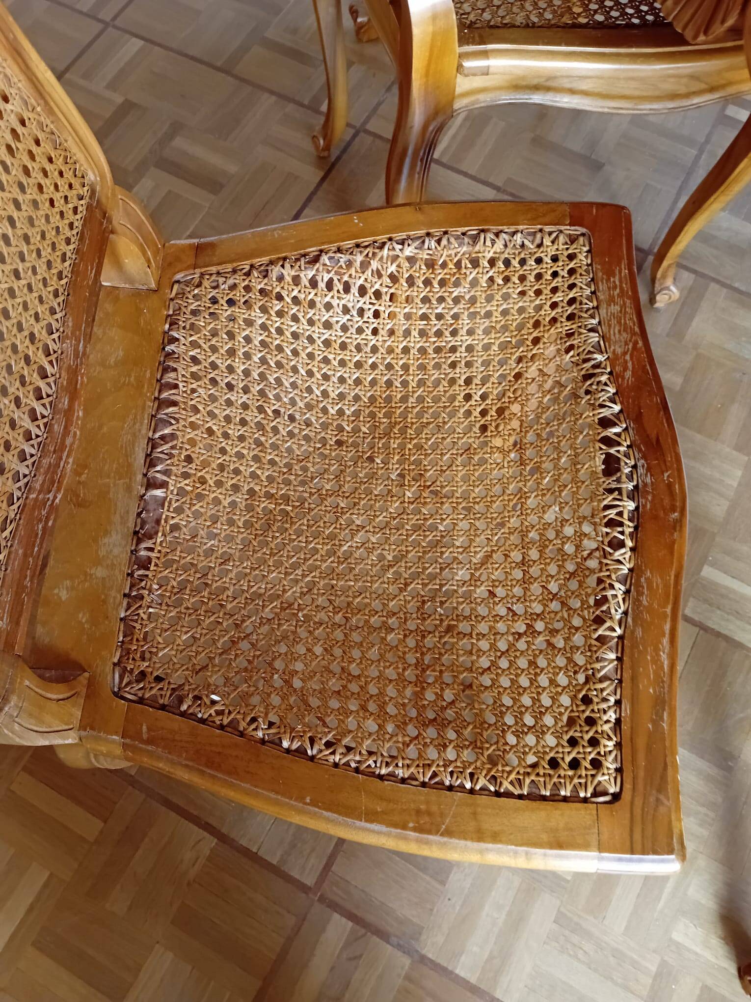 Carved wooden dining table and its 5 rattan caned chairs.