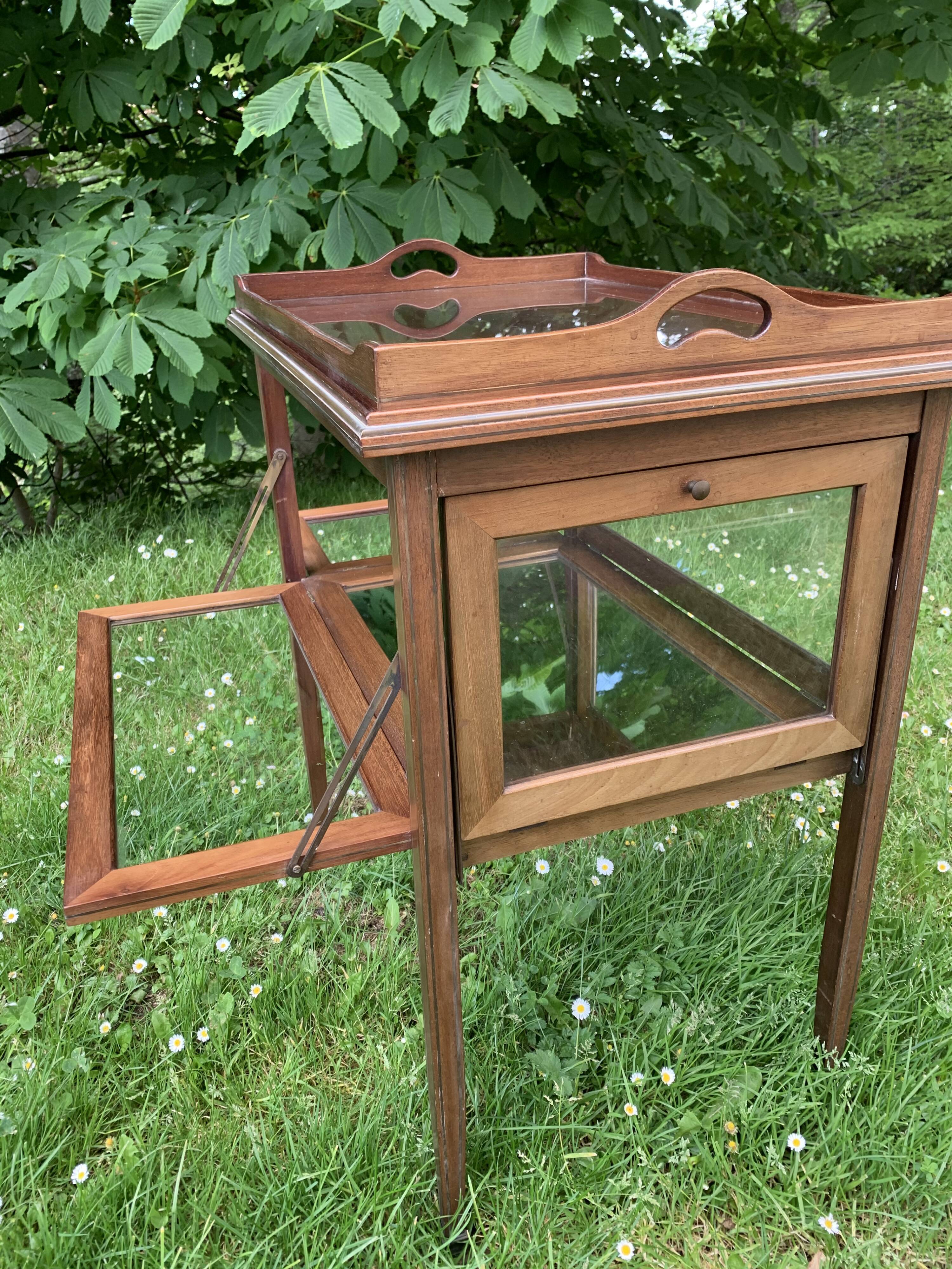 Glass-enclosed old tea table with wooden tray, bronze and brass