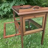 Glass-enclosed old tea table with wooden tray, bronze and brass