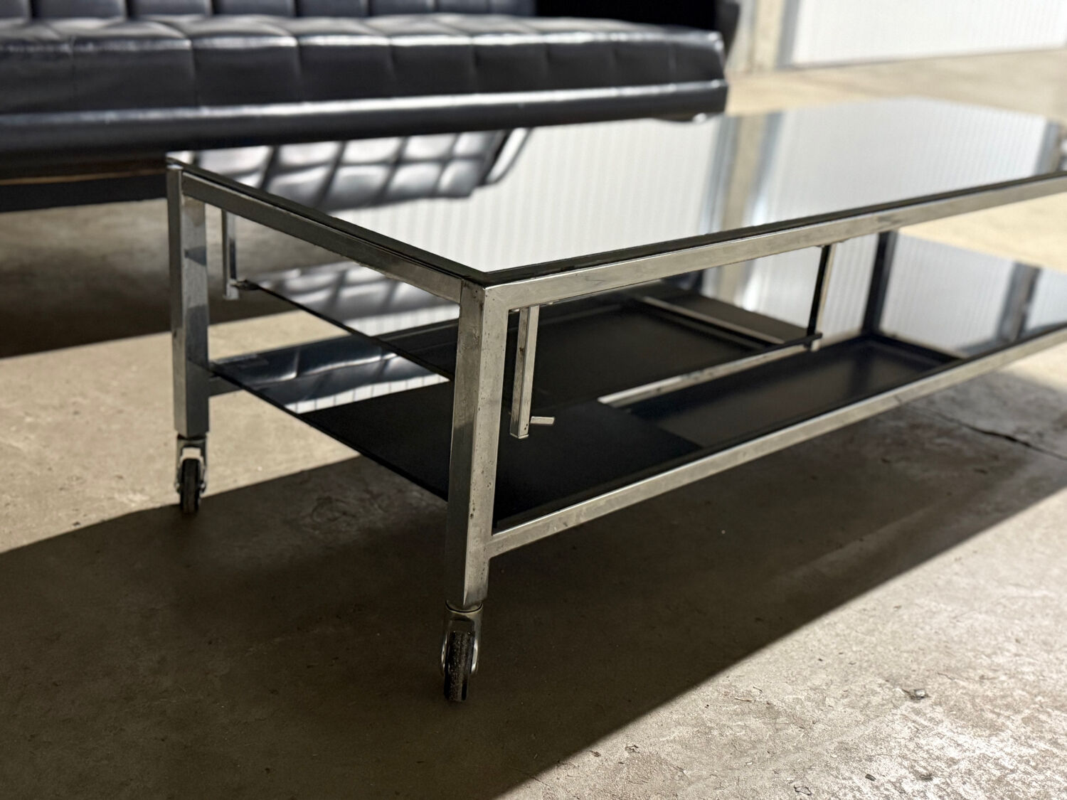 Table basse design vintage chrome et verre fumé noir sur roulettes