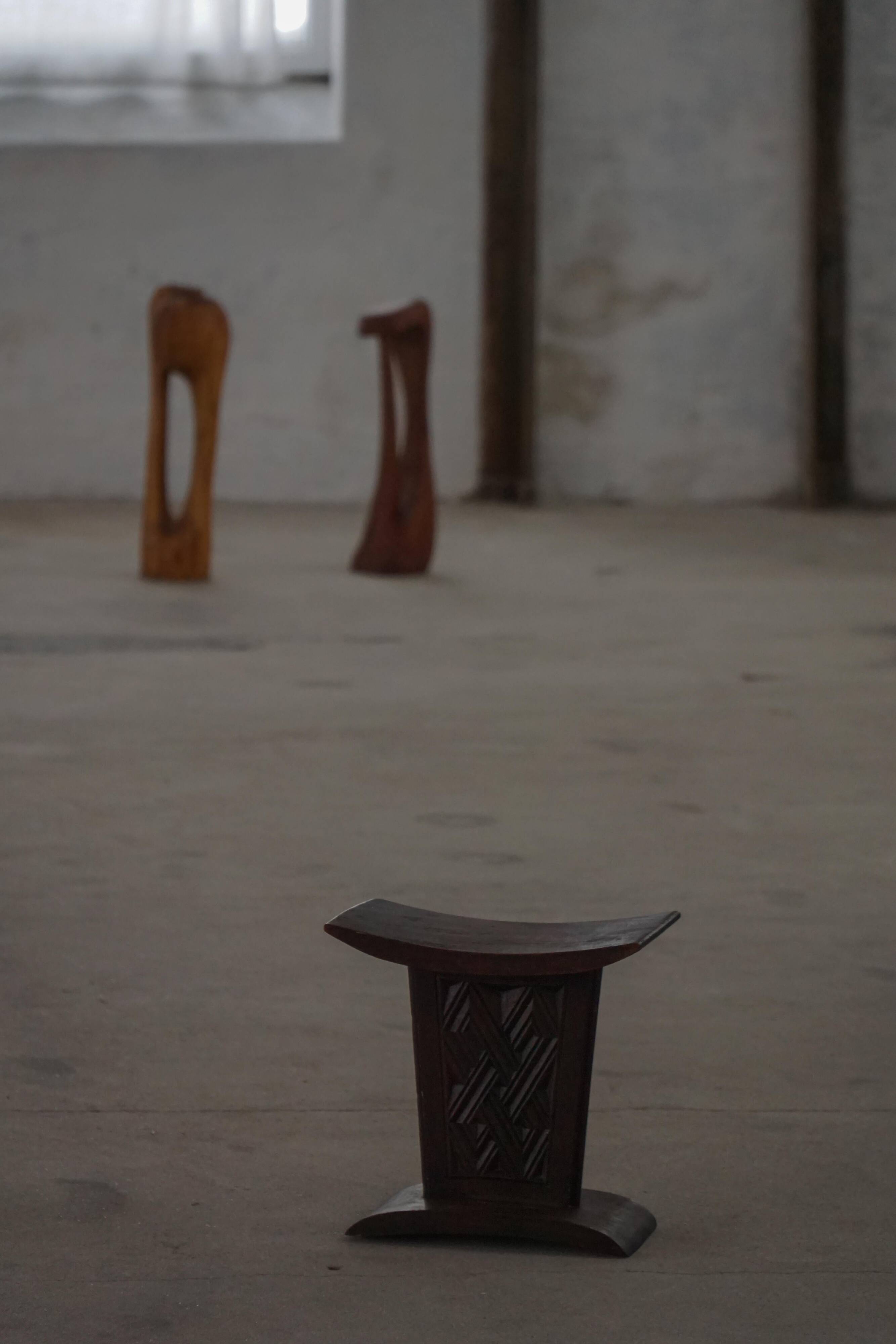 Sculptural African stool in hardwood, curved seat and architectural base, 1970s.