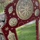 Large oriental mirror with embossed brass decoration on a red velvet background