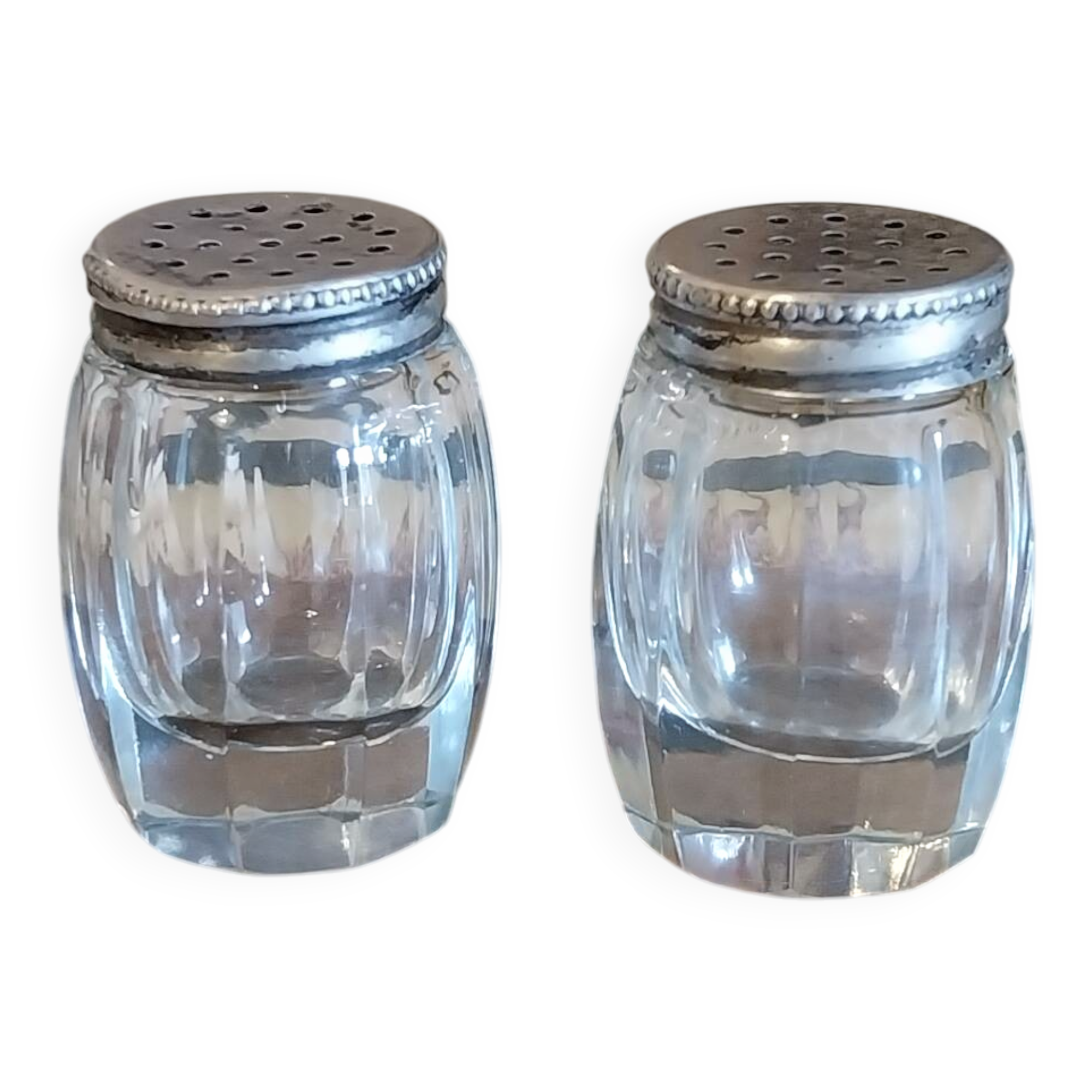 Antique salt and pepper shakers in crystal and silver metal.
