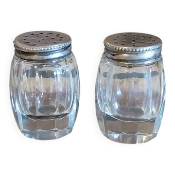 Antique salt and pepper shakers in crystal and silver metal.