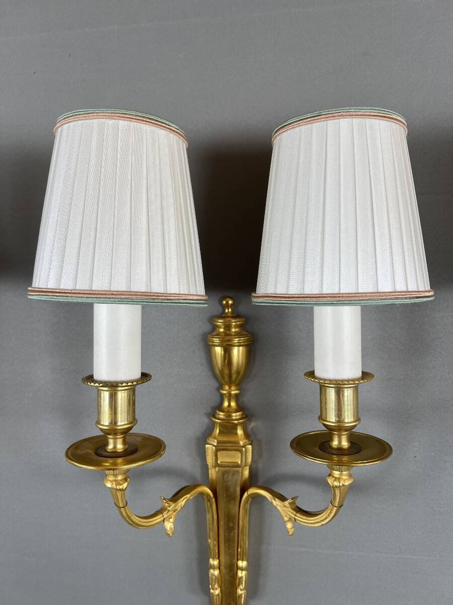 Set of three Louis XVI style wall sconces in gilded bronze, 20th century.