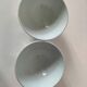 Two vintage farm bowls on a pale blue pedestal with floral decoration.
