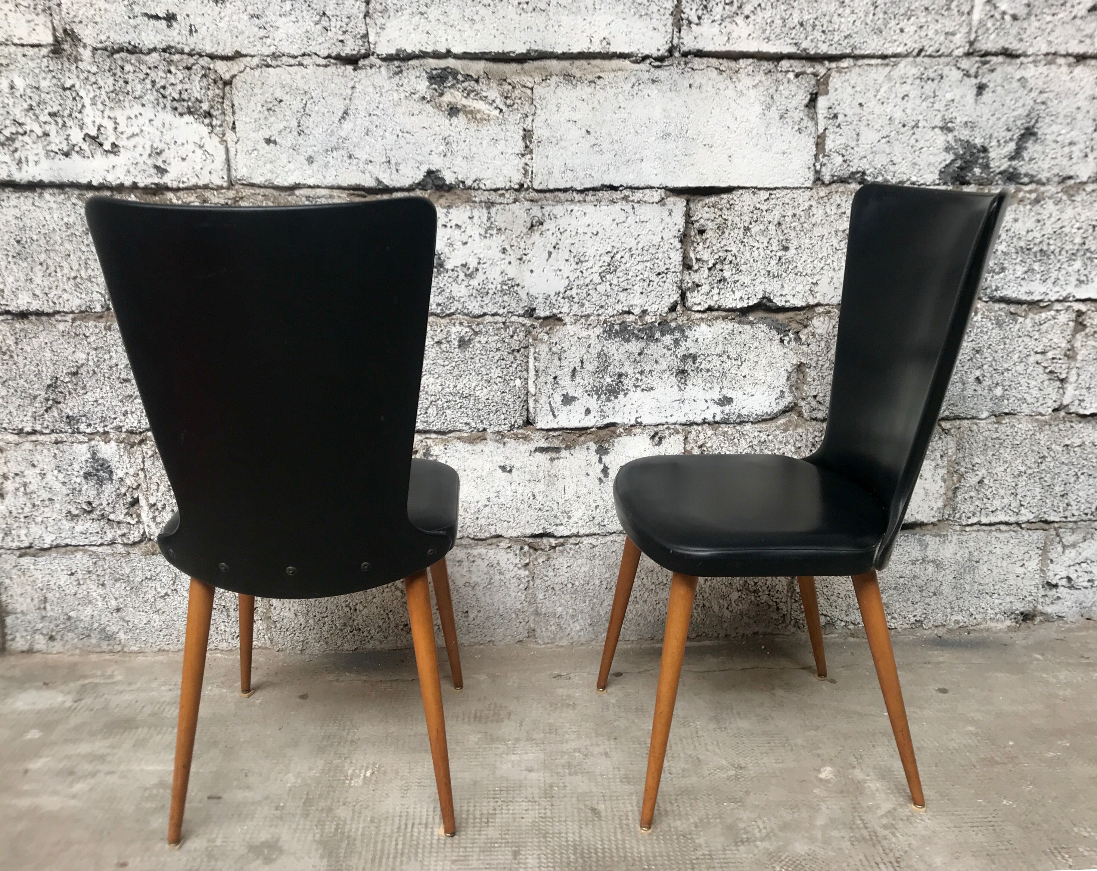 Pair of Baumann model Essor chairs in faux black leather, beech compass footing
