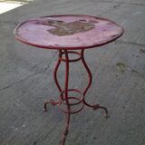 Vintage red cast iron bistro table (1950s) — round metal top, tripod base.