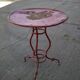 Vintage red cast iron bistro table (1950s) — round metal top, tripod base.