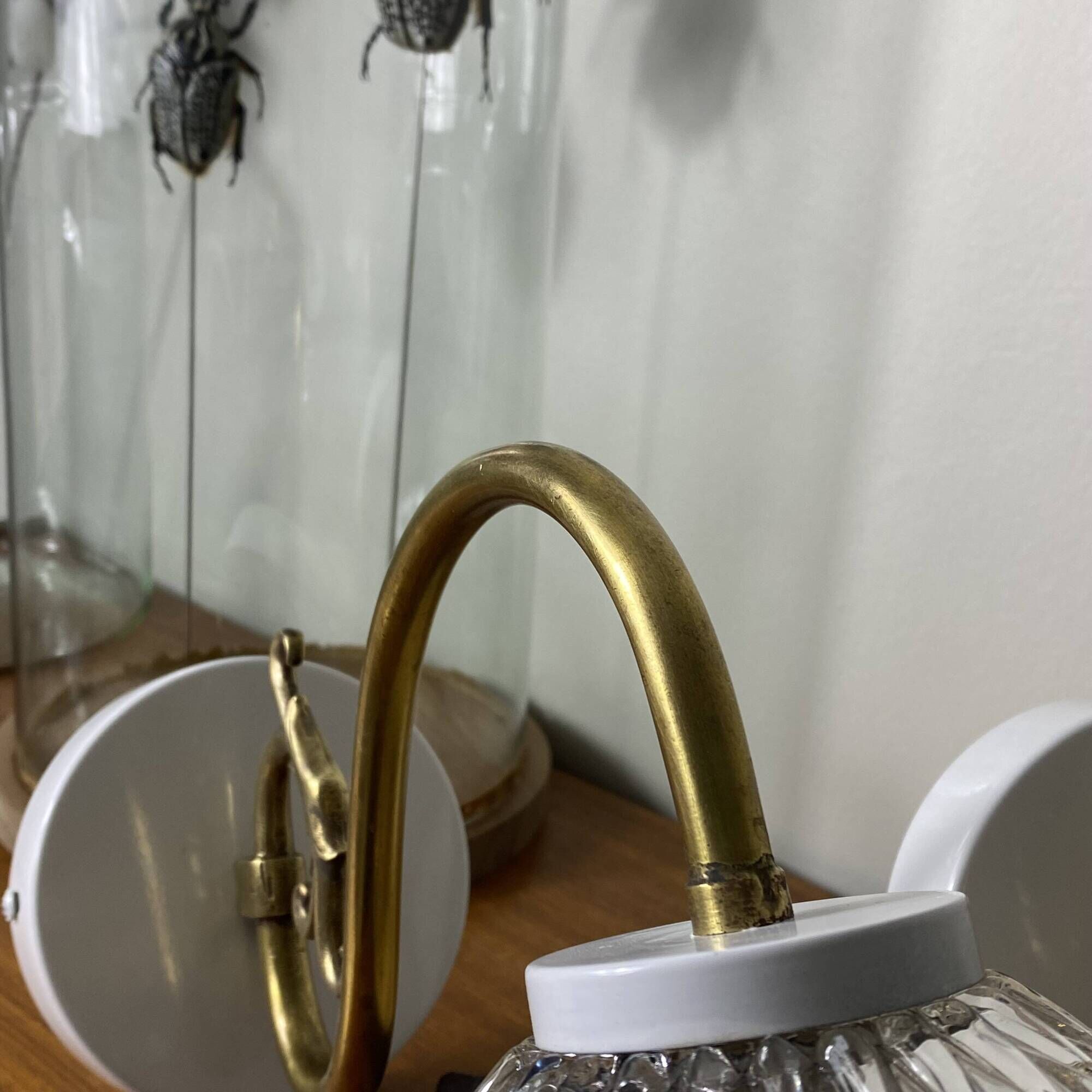 Large pair of brass swan neck wall lights with transparent glass globes.