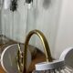 Large pair of brass swan neck wall lights with transparent glass globes.