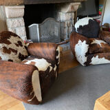 Pair of club chairs covered in cowhide