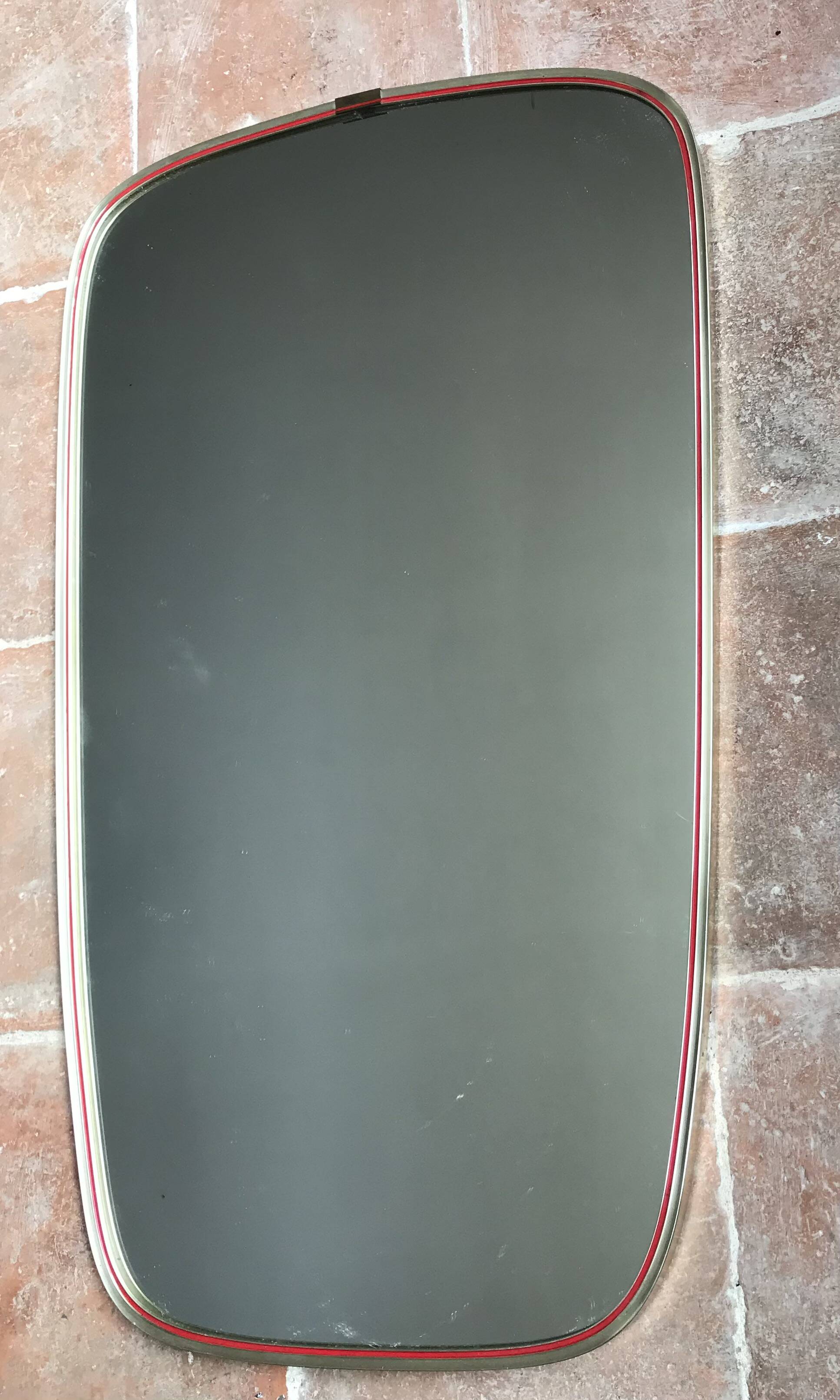 Vintage 1960s mirror in a freeform shape with a gold and red trim.