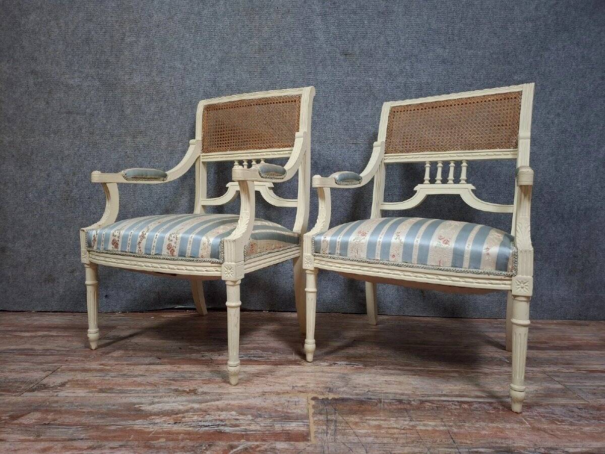 a pair of caned armchairs in the Louis XVI style, elegant and full of charm.