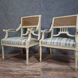 a pair of caned armchairs in the Louis XVI style, elegant and full of charm.