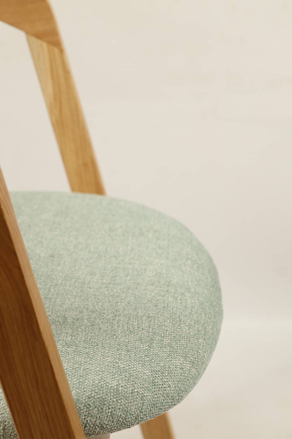 Vintage dining chair in light oak with natural linen pastel green fabric.
