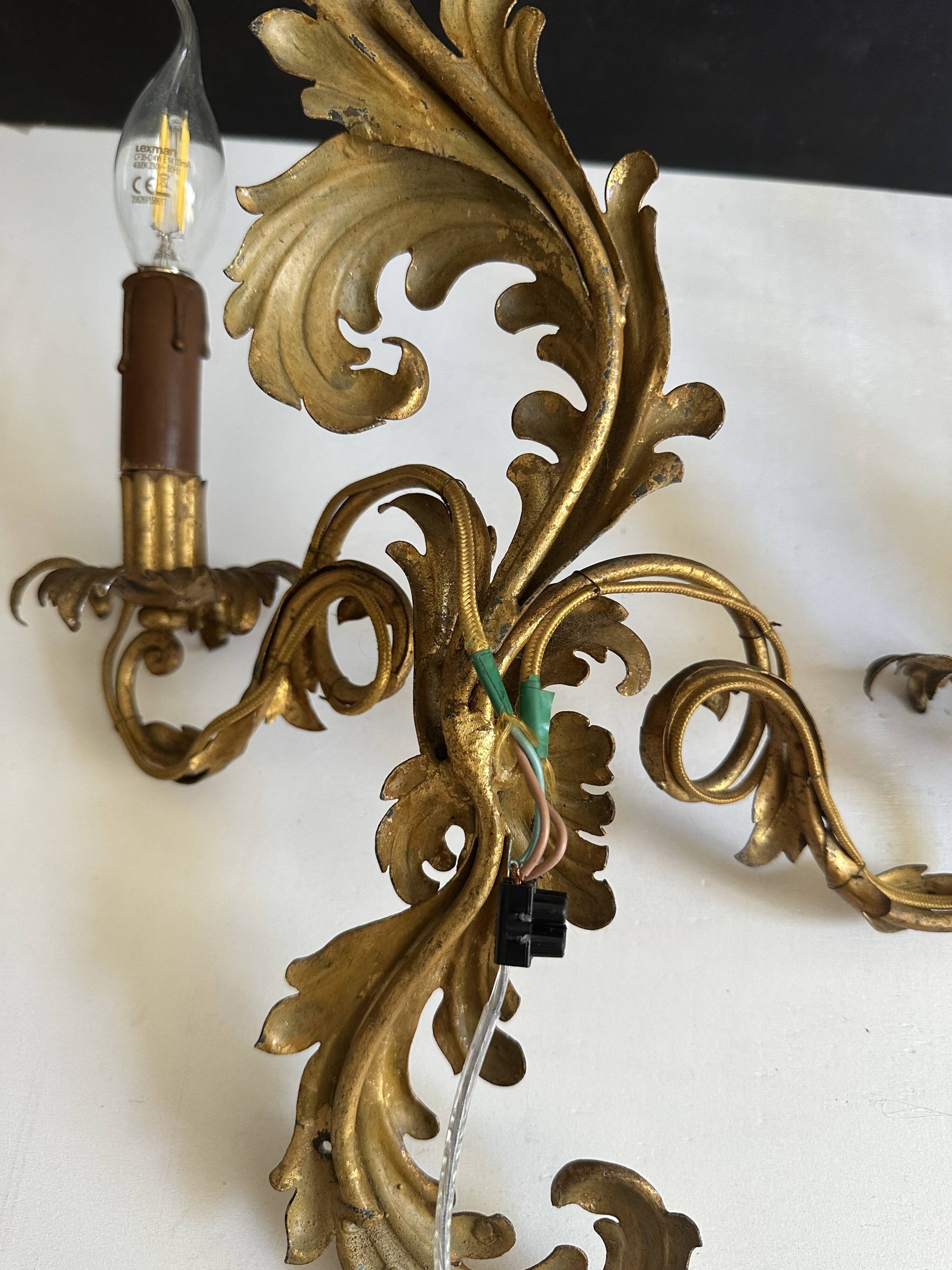 Pair of Italian Hollywood Regency wall lights in iron and gilded sheet metal.