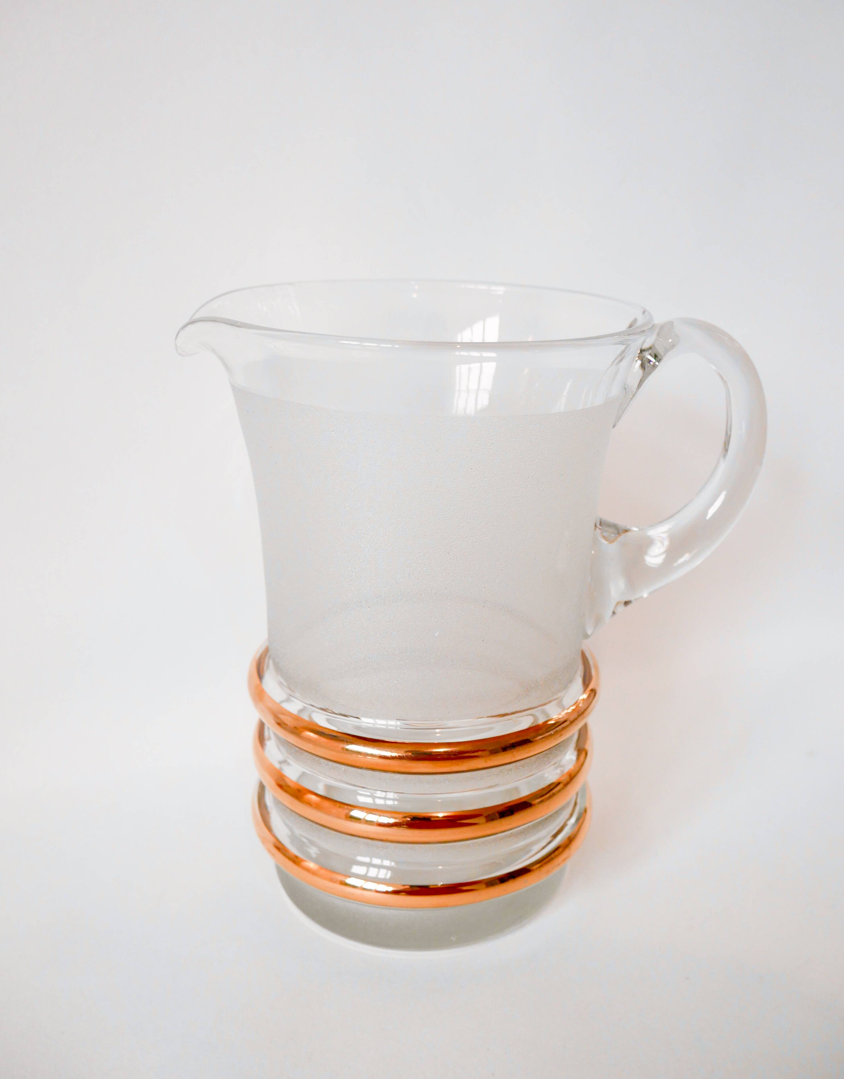 set composed of a pitcher and two large white granite glasses with gold edging from the 60s