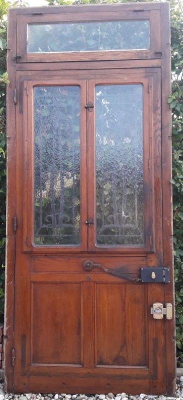Oak entrance door and its frame and transom, wrought iron gates