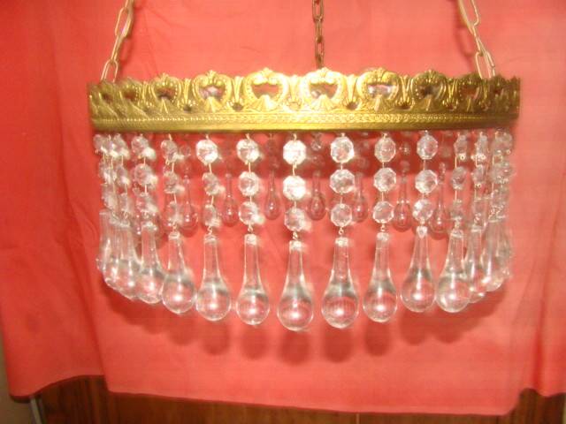 circular chandelier with a brass frame and crystal drops