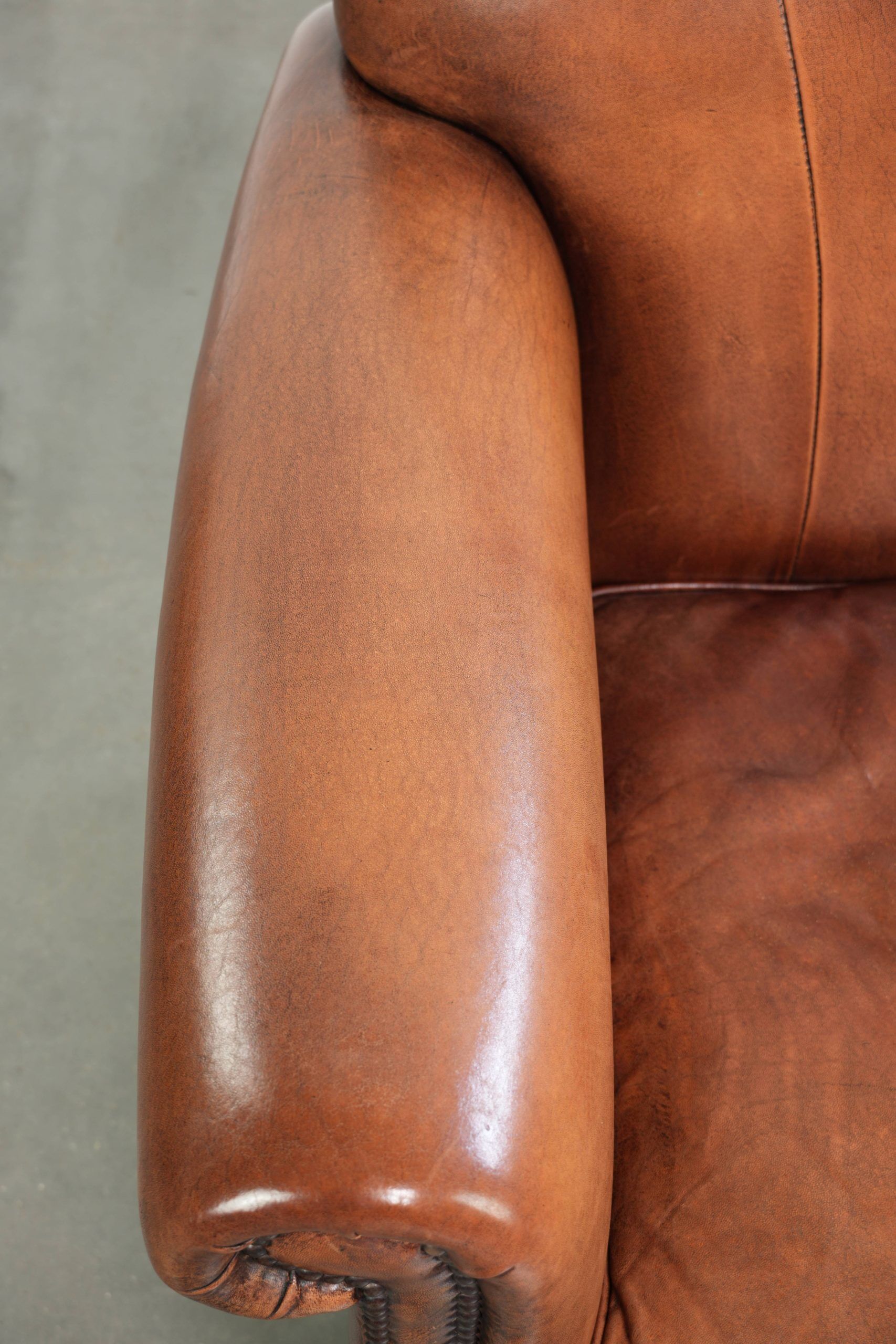 Sheepskin armchair with comfortable seat and finished with decorative nails