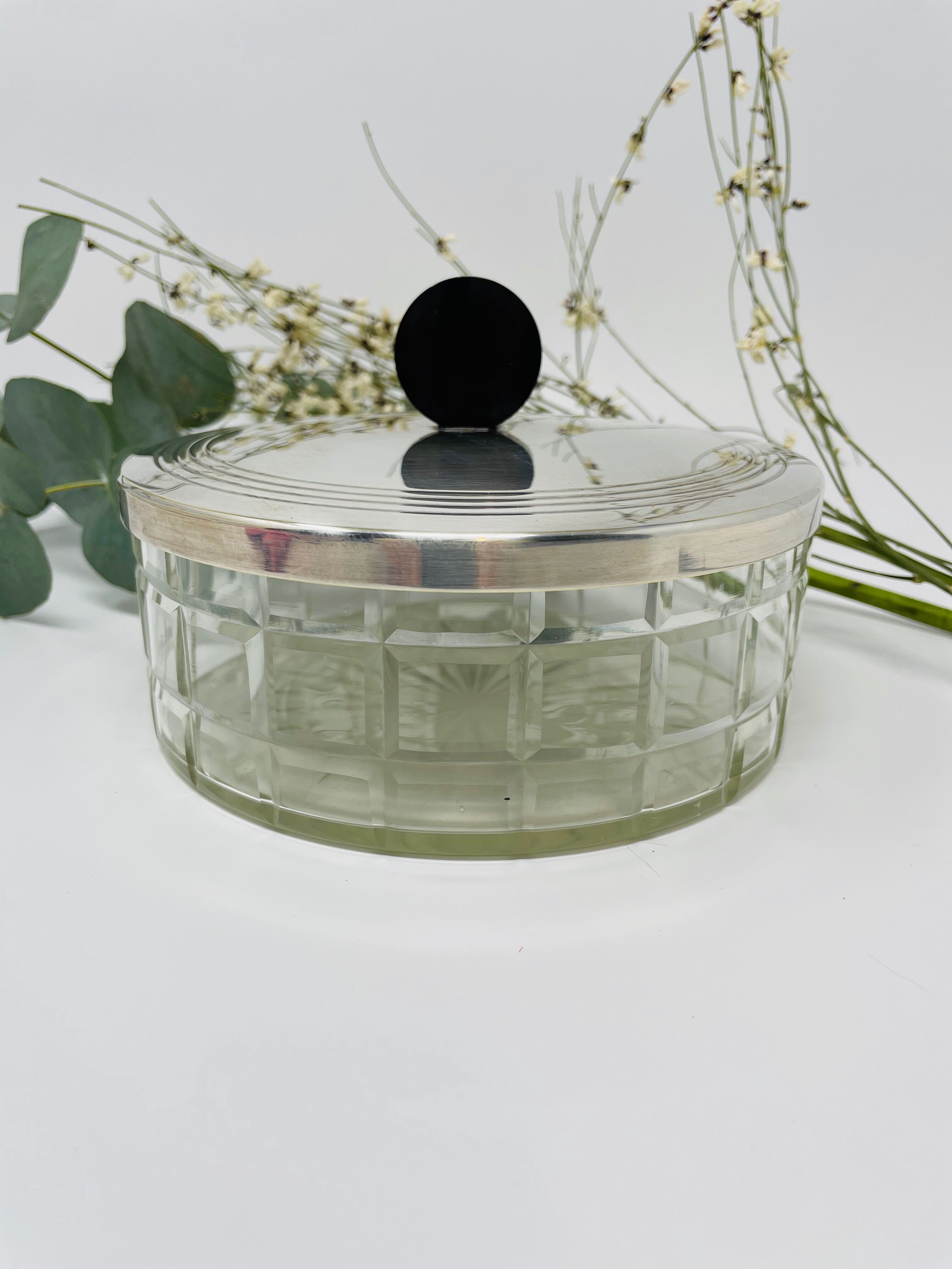 Vintage box made of chiseled glass and covered metal, taken in black Bakelite